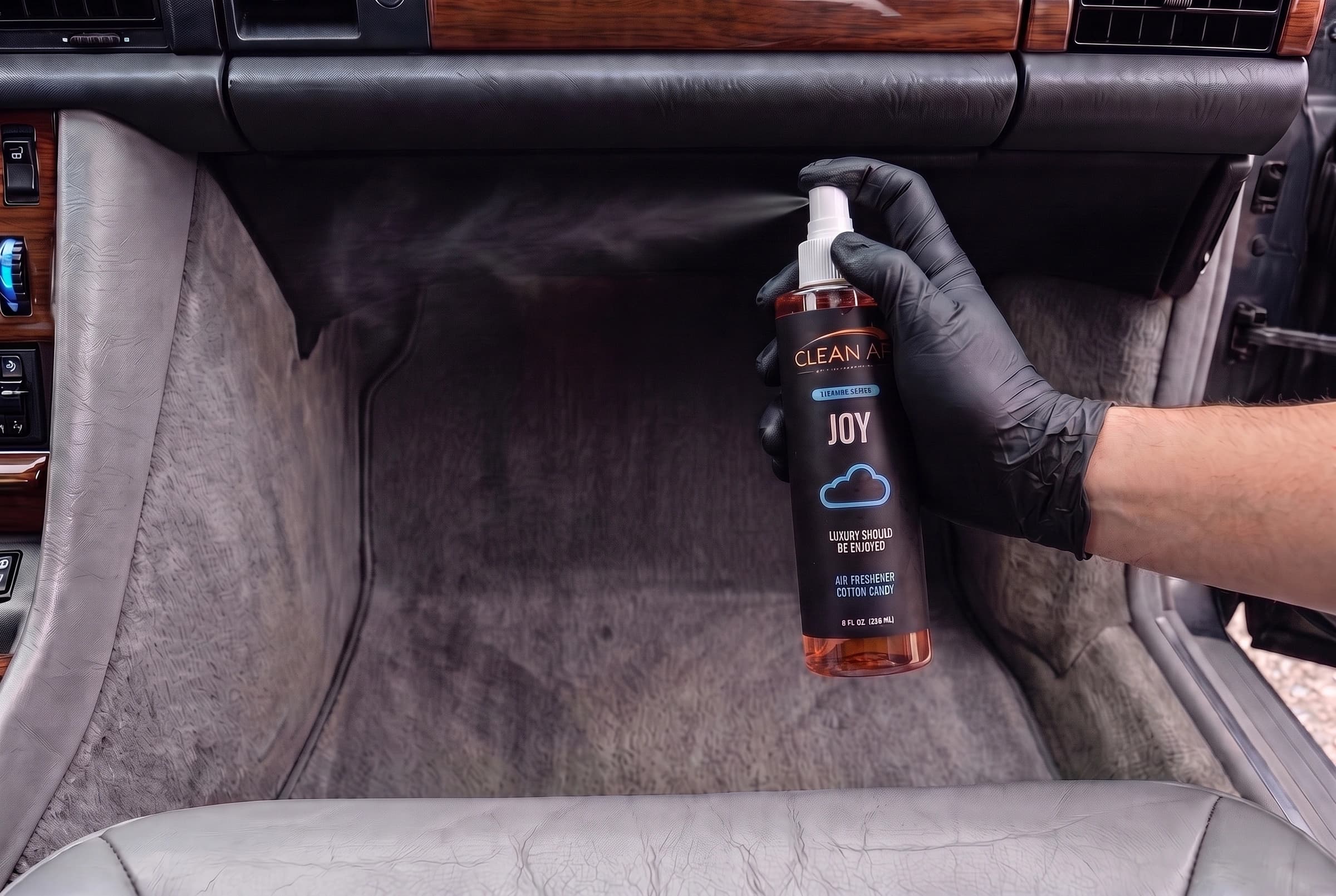 The original JOY finger pump spraying into the air beneath the glove compartment, above the passenger footwell