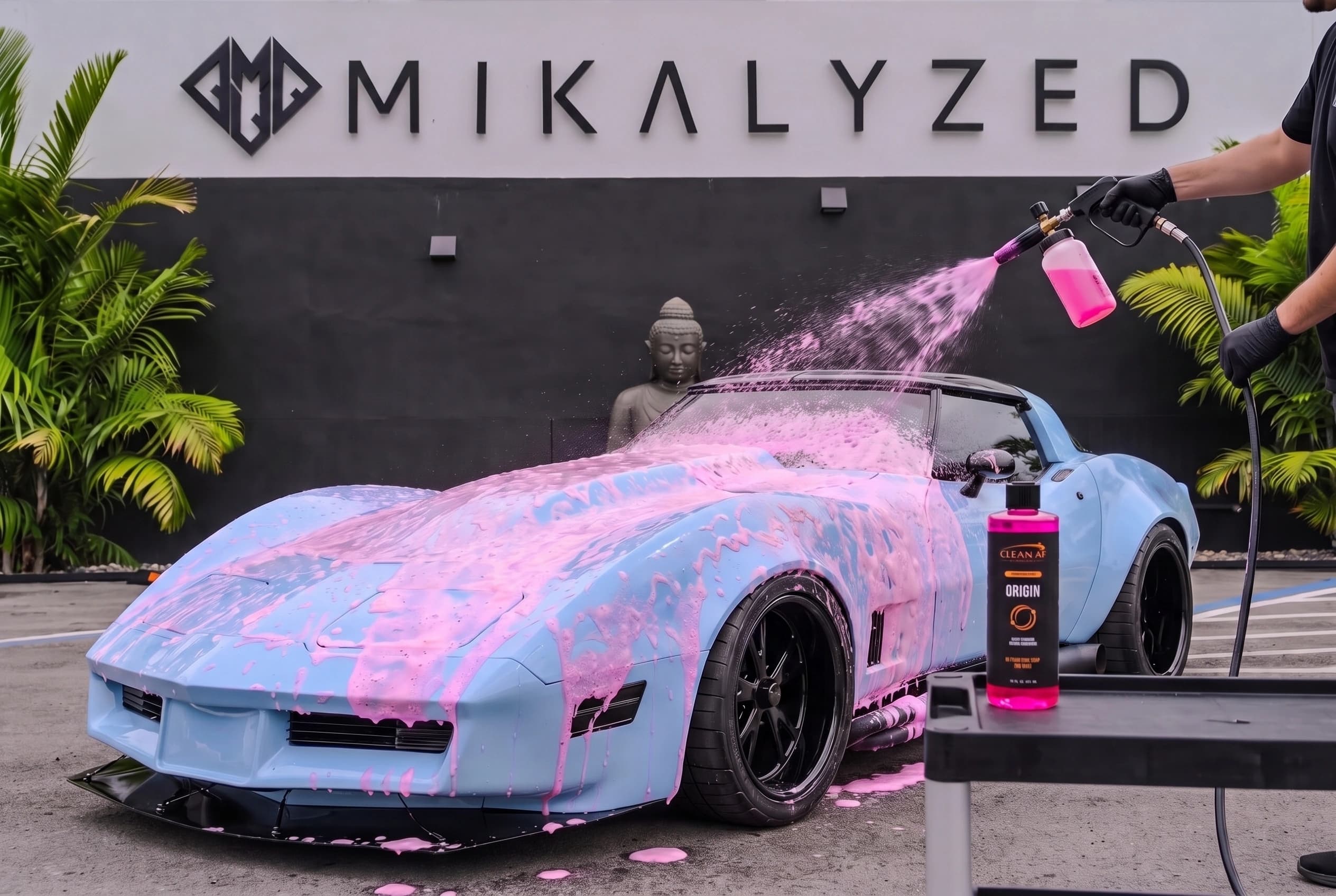 ORIGIN beside a light-blue Corvette receiving foam from a foam cannon