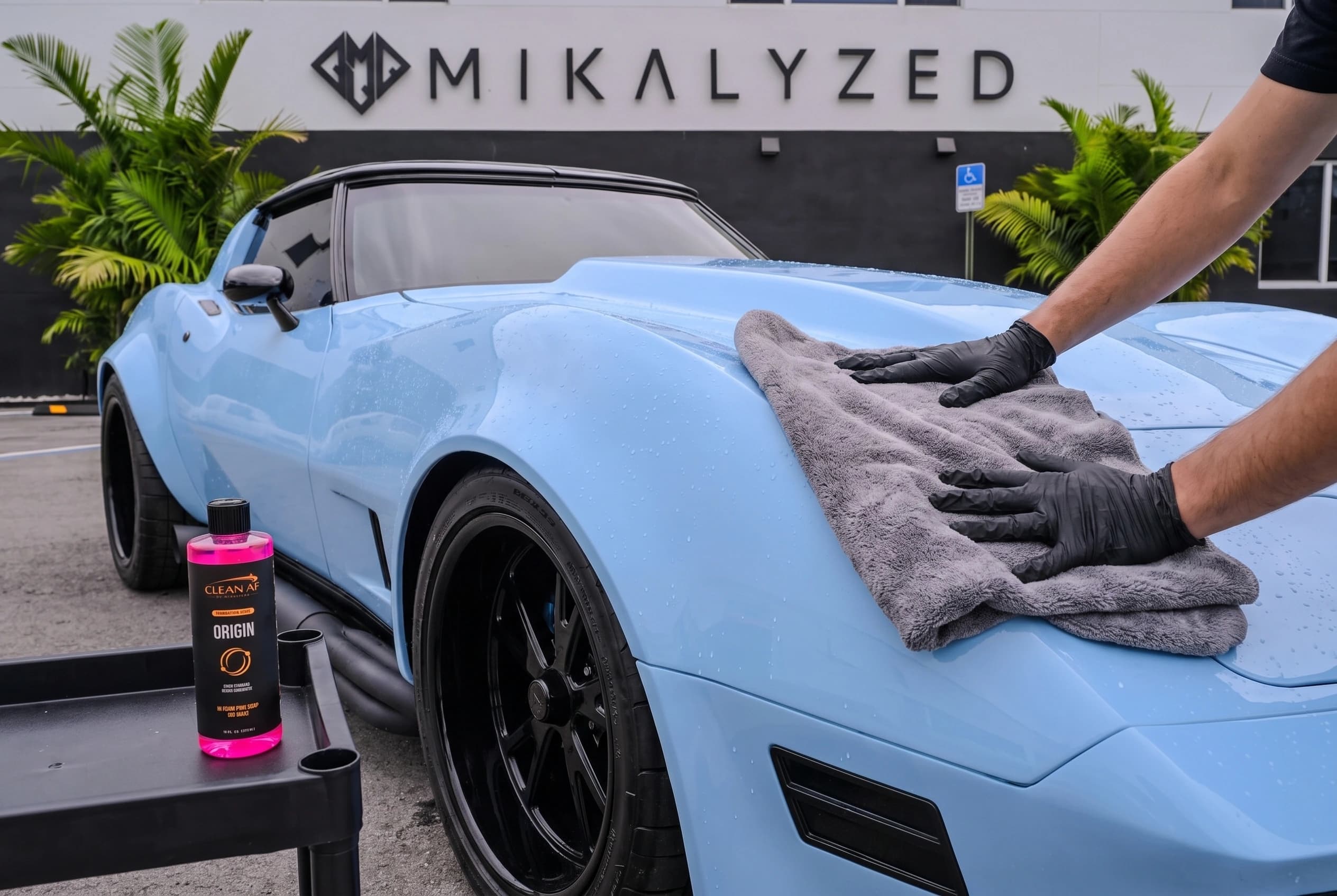 A microfiber towel drying the clean, rinsed Corvette hood