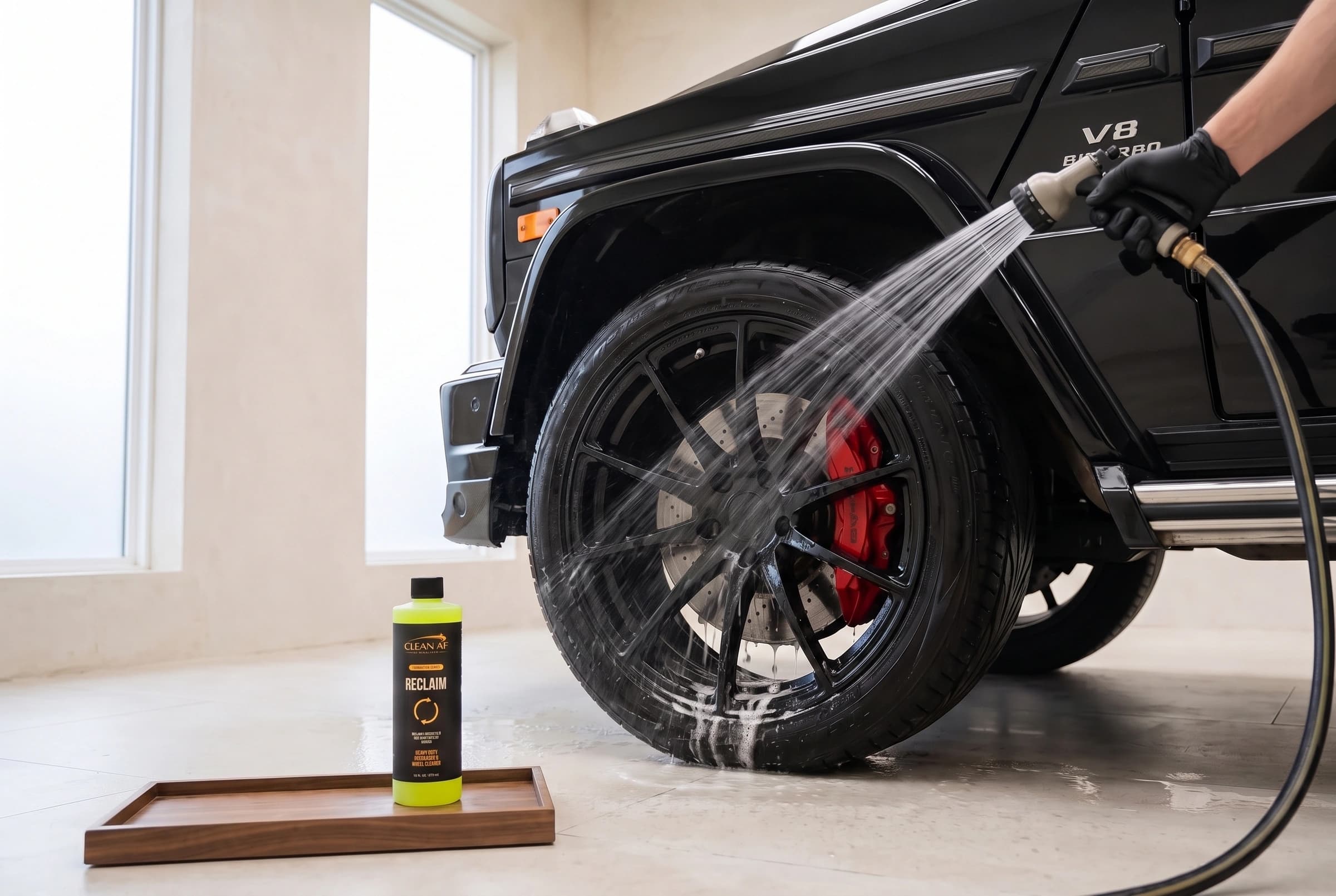Clean water rinsing the black Mercedes G63 wheel after agitation